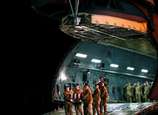An Army carry team moves the flag-draped transfer case containing the remains of U.S. Army soldier Maj. Sorffly Davius, who died in Kuwait, during a casualty return, Monday, March 9, 2026, at Dover Air Force Base, Delaware.