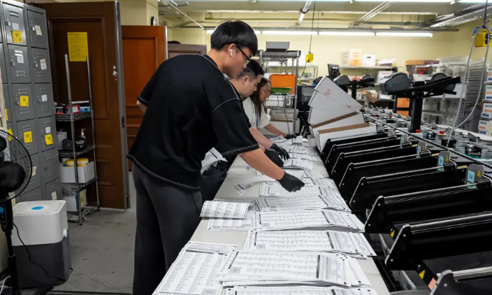 Election workers process mail-in ballots